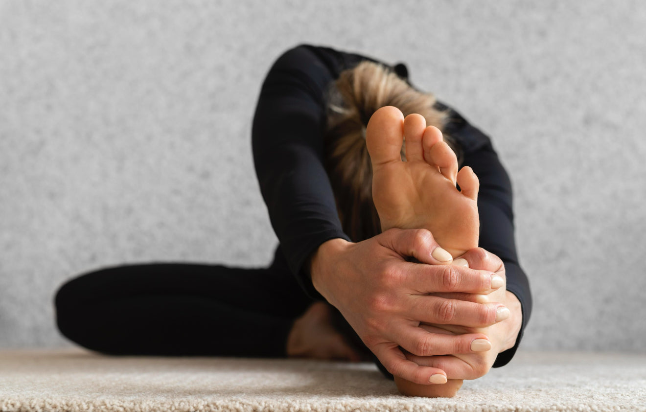 une femme qui s'étire en appuyant sur son talon pour soulager les douleurs aux pieds